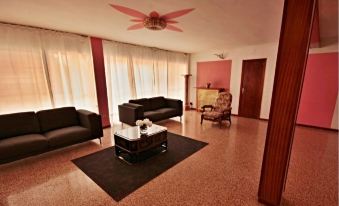 a modern living room with brown leather couches , a black coffee table , and pink walls at Alegria