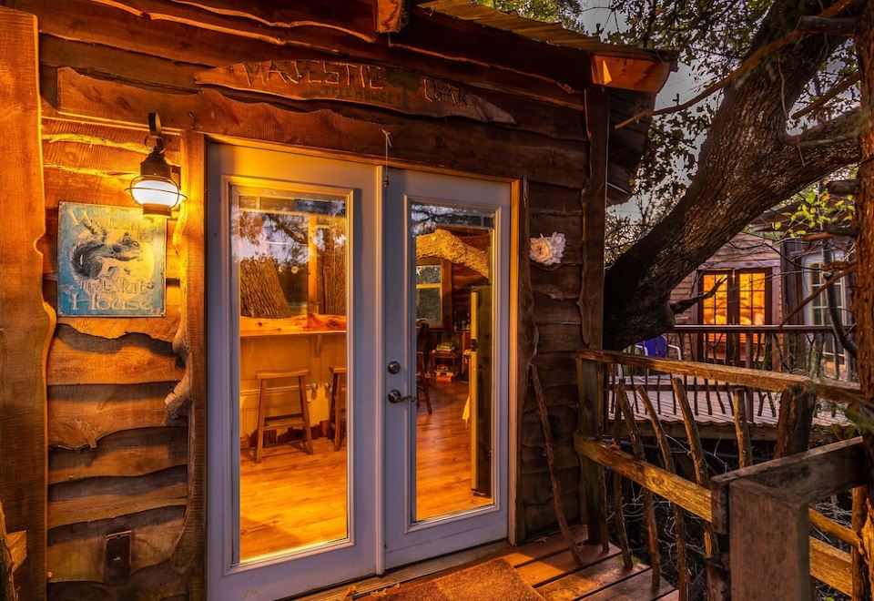 a small wooden cabin with a wooden porch , two glass doors that open to reveal a dining area at Savannah's Meadow