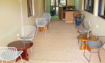 a long hallway with several chairs and tables arranged in a row , creating a seating area for visitors at Hotel Lewi