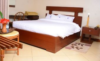 a large wooden bed with white sheets and a wooden headboard is in a room at White Horse Inn
