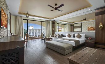 a spacious bedroom with hardwood floors , a large bed , and a balcony overlooking the ocean at Resort Rio