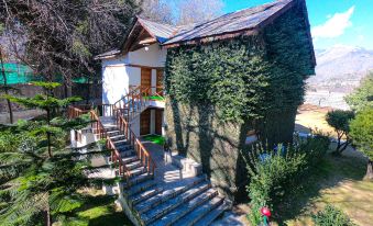 a small wooden house surrounded by trees and bushes , with a staircase leading up to it at Apple Valley Resort