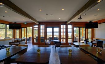 a large dining room with wooden tables and chairs arranged for a group of people to enjoy a meal at Sproat Lake Landing Resort