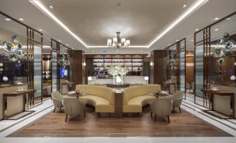 a hotel lobby with a couch , chairs , and a coffee table in the center of the room at DoubleTree by Hilton Skopje