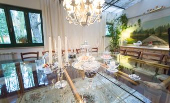 a dining room with a large glass table , surrounded by chairs , and a chandelier hanging above at Casa Matilde