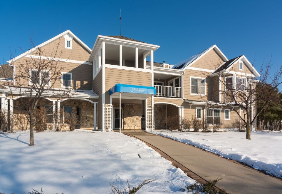 a snow - covered street with two houses , one on the left and the other on the right at Newport Resort