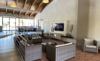 a spacious living room with a large flat - screen tv mounted on the wall , surrounded by multiple couches and chairs at Park Royal Homestay Club Cala Puerto Rico