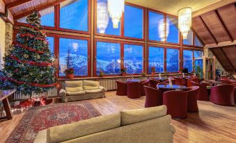 a large , modern living room with multiple couches and chairs arranged around a christmas tree at Hotel Mondole