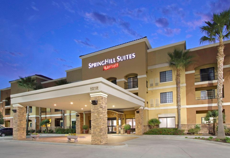 the exterior of a springhill suites hotel , with its sign and surrounding area illuminated against the night sky at SpringHill Suites Madera