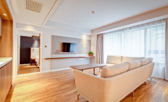 The living room is modern and features large windows, a TV, and a wood-paneled accent wall at Holiday Inn Express Xi'an Bell Tower