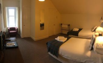 a room with two beds , one on the left side and the other on the right side of the room at Loch Shiel Hotel