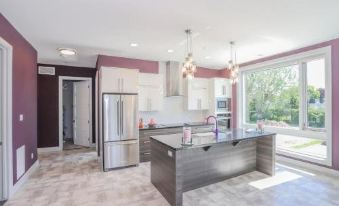 a modern kitchen with a large island , stainless steel appliances , and white cabinets , under a contemporary design at My Place