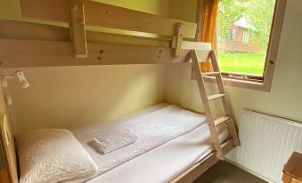 a small room with two bunk beds , one on top of the other , and a window at Hörgsland Cottages