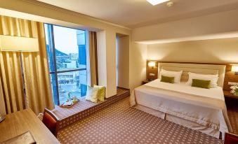 a hotel room with a king - sized bed , a large window , and a view of the city at Central Plaza Hotel
