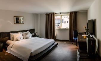 a modern hotel room with a large window , white bed , and wooden flooring , offering a view of the city at Cochin Zen Hotel