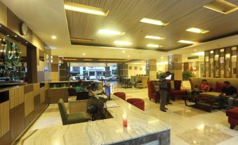 a large hotel lobby with marble floors , a reception desk , and several people sitting around it at Lorin Dwangsa Solo Hotel
