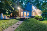 Luxurious midcentury modern glass house in the woods, chefs kitchen & great art