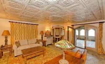 a living room with a couch , coffee table , and lamp is shown with an ornate ceiling at Highlands Castle Overlooking Lake George Plus 2 Other Castles & Suites