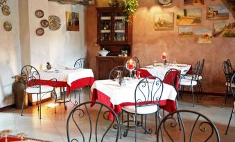 a restaurant with red and white tablecloths on dining tables , creating a cozy atmosphere for guests at Etna Hotel