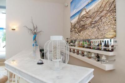 a modern kitchen with a white marble countertop , a hanging fan , and a large painting on the wall at Hotel Summery