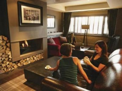 a woman and a child are sitting on a couch in a living room , enjoying each other 's company while looking at each other at Village Hotel Liverpool