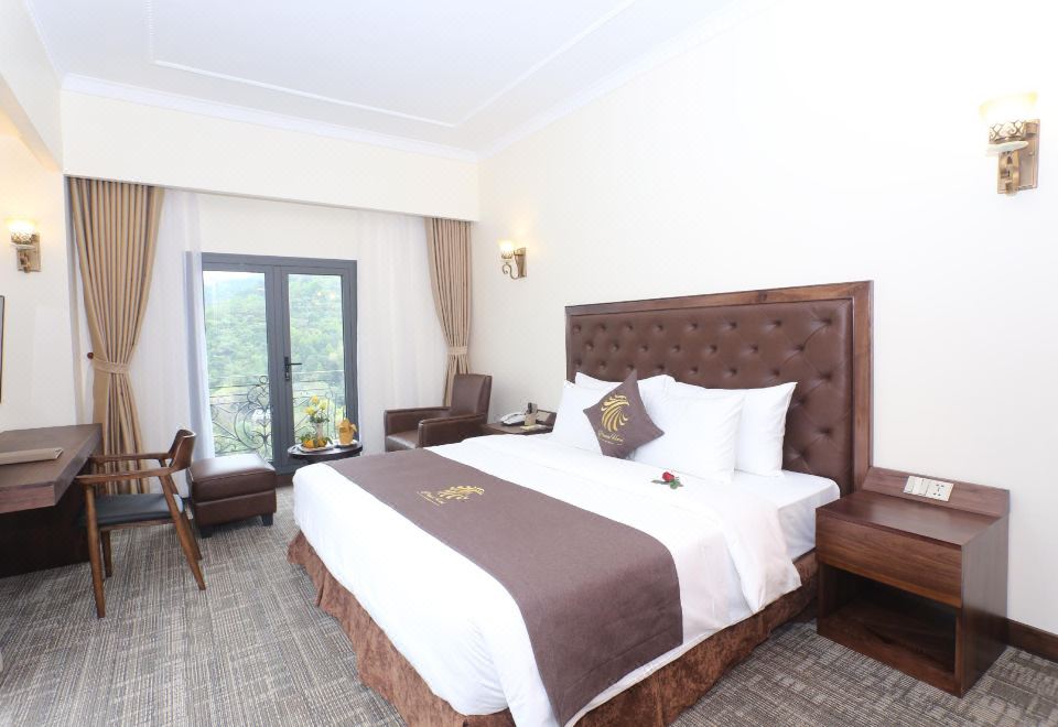 a large bed with a brown headboard and white linens is in a hotel room at Phoenix Hotel