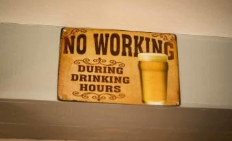 "a sign that reads "" no working during drinking hours "" is hanging on a wall in a room" at The Chequers Inn