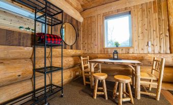 a cozy cabin interior with wooden walls , a black shelf , and a window , featuring stools and a table at Boulder Mountain Resort