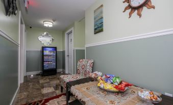 a room with a couch , a table , and a clock on the wall , along with a vending machine at Cold Spring Hotel