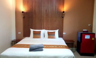 a large bed with white sheets and two pillows is situated in a room with wooden walls at The Sekret Hotel