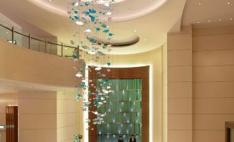 A large room is illuminated by an overhead light fixture, featuring an illuminated ceiling and a chandelier in the center at Auberge Discovery Bay Hong Kong