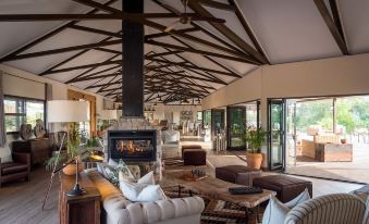 a spacious living room with a fireplace and large windows , creating a warm and inviting atmosphere at Old Drift Lodge
