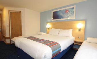 a hotel room with three beds , one on the left , one in the middle , and one on the right at Travelodge Glenrothes