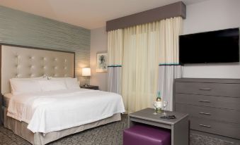 a hotel room with a king - sized bed , a flat - screen tv mounted on the wall , and a closet at Homewood Suites by Hilton Allentown Bethlehem Center Valley