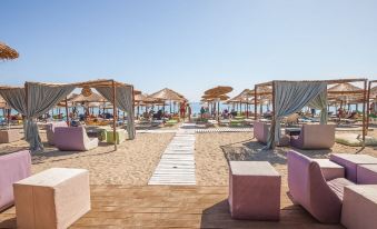 a sandy beach with numerous lounge chairs and umbrellas set up on the sand , creating a relaxing atmosphere at Olympian Bay Grand Resort