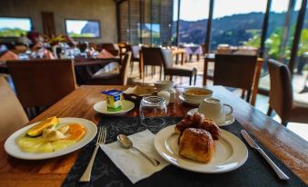 a table is set with a variety of breakfast items , including pastries , eggs , and coffee at Isalo Rock Lodge