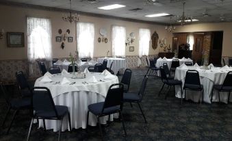 a well - decorated dining room with tables covered in white tablecloths and chairs arranged around them at Hotel Strasburg