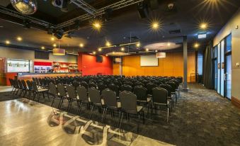 a large conference room with rows of chairs arranged in a semicircle , providing seating for a large group of people at Nightcap at Matthew Flinders Hotel