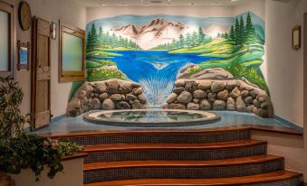 a mural of a waterfall and mountains is displayed on the wall of a room at Hotel Lo Scoiattolo
