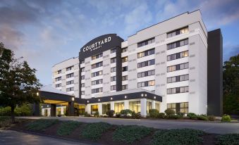 the courtyard by marriott is a large hotel with white and black exterior , surrounded by trees and grass at Courtyard Shelton