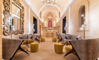 a large , elegant room with high ceilings , multiple couches , chairs , and a chandelier hanging from the ceiling at Hotel Creu de Tau Art&Spa-Adults Only