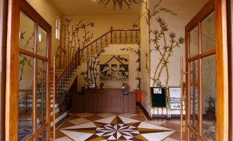 a foyer with a staircase leading to the second floor , a large painting on the wall , and a potted plant at Country Roads