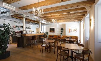 a dining room with wooden tables and chairs , as well as a bar area with several stools at Fleur de LIS