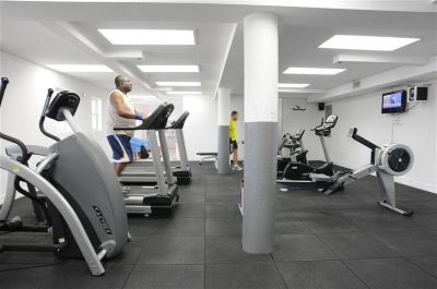a man is working out on a treadmill in a well - equipped gym with other exercise equipment at Wyndham Reef Resort Grand Cayman