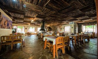 a rustic dining room with wooden tables and chairs arranged for a large group of people to enjoy a meal together at Canyon Lodge