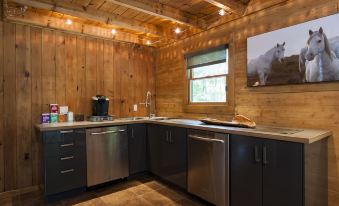 a kitchen with wooden walls and a wooden ceiling , featuring stainless steel appliances and a coffee maker at Chatfield Hollow Inn