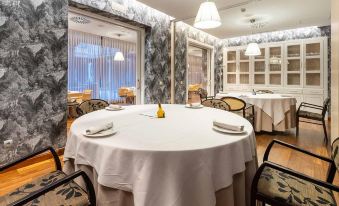 a dining room with several tables and chairs arranged for a group of people to enjoy a meal together at Castilla Termal Olmedo