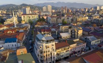 a cityscape with buildings and mountains in the background , taken from an aerial view during sunset at Hotel Old Town