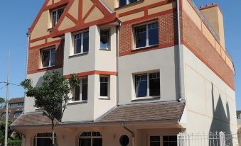 a two - story building with a red and white facade , situated in a city street near a street lamp at Red Fox