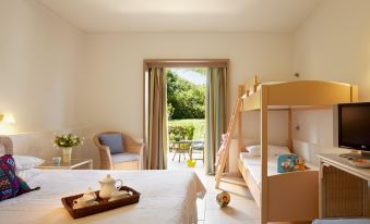 a spacious bedroom with a large bed , a window with a view of trees , and a rocking chair at Grecotel Meli Palace